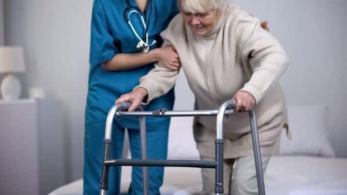 nurse assisting patient - hip replacement surgery recovery time
