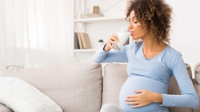Pregnant woman drinking glass of milk