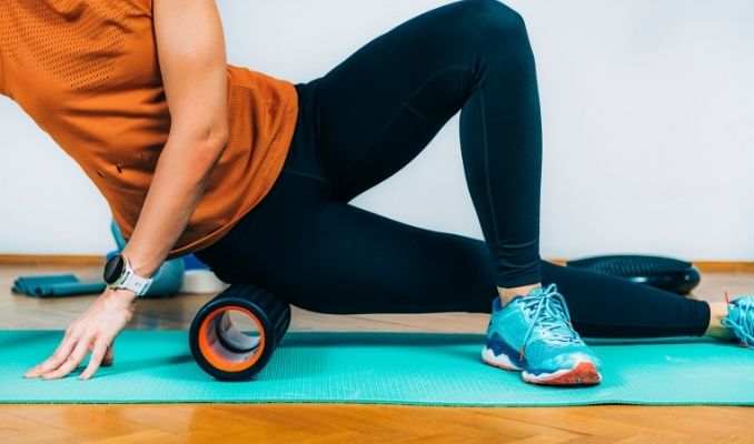 woman-using-foam-roller-massager-at-home